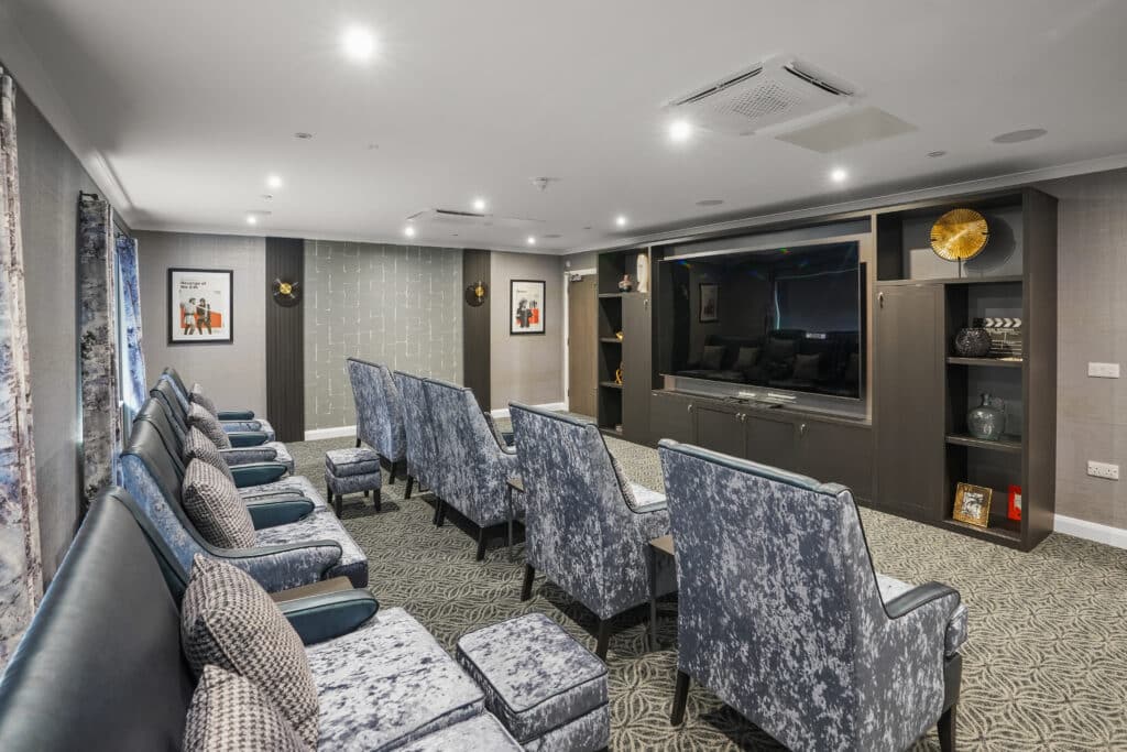Cinema room within an LNT Care Developments care home, fitted with in-ceiling audio and a large display